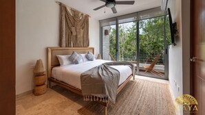 A bedroom with a bed, a ceiling fan, a large window, and a view of trees. - NHOA 208B Lux 1BR Condo Jungle View in Aldea Zama (Tulum)