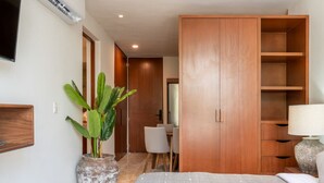 Ein Schlafzimmer mit Bett, Kleiderschrank, Schreibtisch und Stuhl.