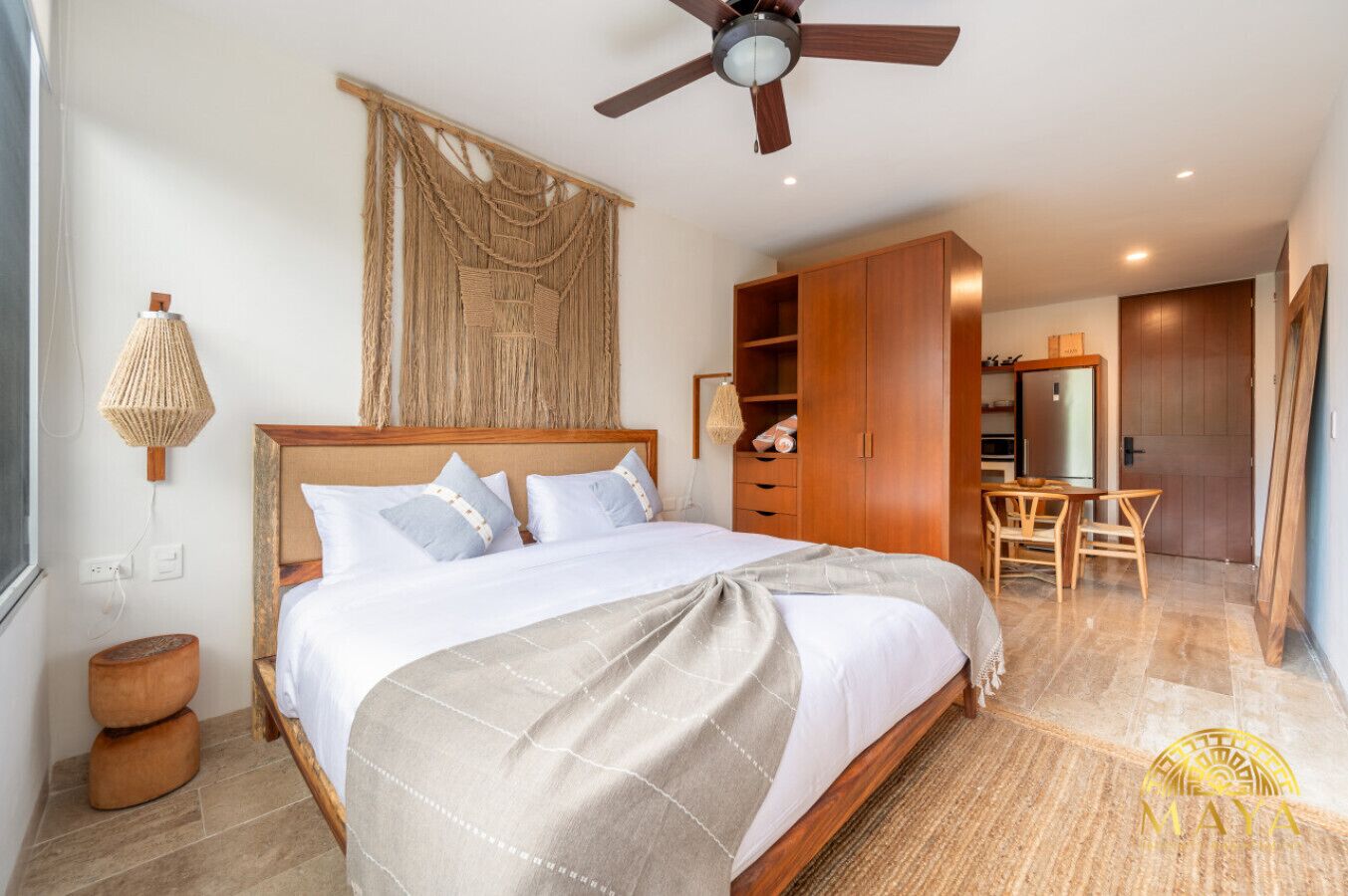 Un dormitorio con cama, armario de madera, escritorio y silla.