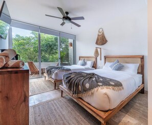 Un dormitorio moderno con una cama grande, un ventilador de techo y vistas al exterior.