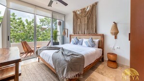 Una camera da letto con un letto, una ventola a soffitto, un'ampia finestra e vista su alberi.