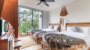 A modern bedroom with two beds, a ceiling fan, a large window, and a view of greenery. - NHOA 311C Lux 1BR Condo Pool View in Aldea Zama (Tulum)