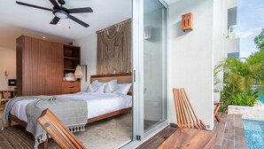 Une chambre moderne avec un lit, des meubles en bois, un ventilateur de plafond et une porte vitrée donnant sur un espace piscine.