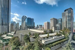 A cityscape with modern high-rise buildings, a mix of glass and concrete architecture, and a clear blue sky. - 2BR, 2BA Cozy, Central, Downtown Convention Center (Seattle)