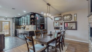 Una cocina amplia con armarios oscuros, una mesa de comedor de madera y una araña.