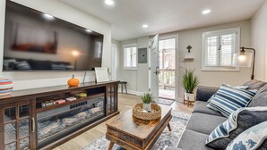 Una sala de estar con televisor, sofá, mesa de centro y chimenea.