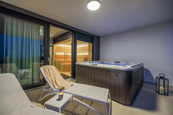 A modern balcony with a hot tub, a lounge chair, and a candle on a small table. - Villa LEA MAGDALENA III (Krk)