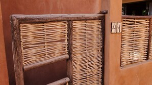 A rustic building with a wooden door and window shutters.