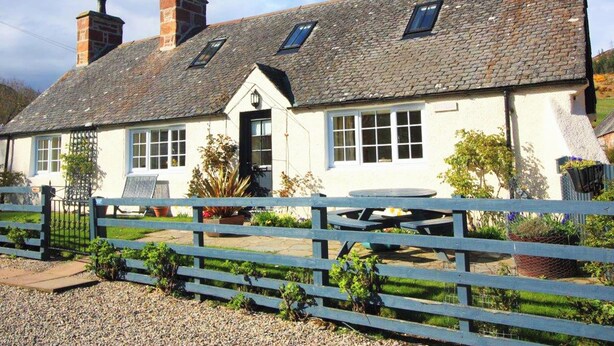 A traditional stone-roofed building with multiple windows, a front door, and a gravel driveway. - White Cottage - UK7679 (Golspie)