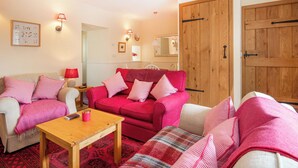 A cozy living room with two sofas, a wooden coffee table, and a chandelier. - White Cottage - UK7679 (Golspie)