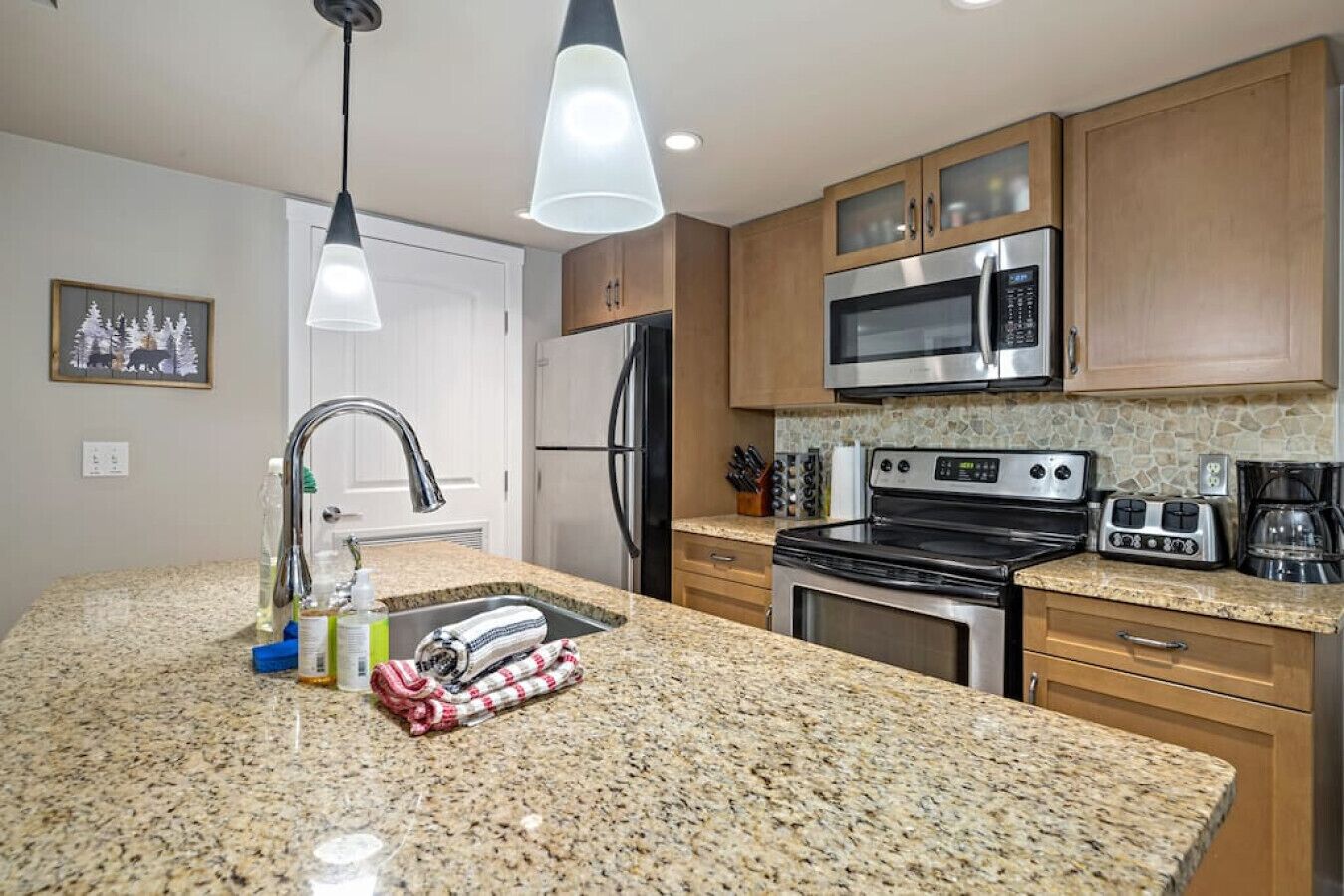 A modern kitchen with granite countertops, stainless steel appliances, and wooden cabinets.