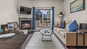 A living room with a fireplace, sofa, coffee table, and a TV.