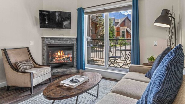 A living room with a fireplace, a sofa, a chair, and a coffee table.