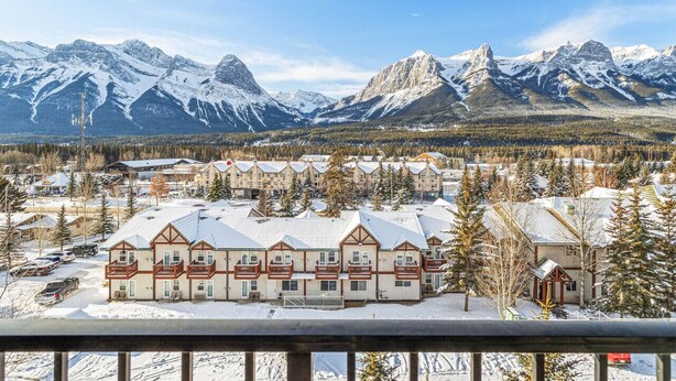 A hotel with multiple buildings, snow-covered surroundings, and mountains in the background.