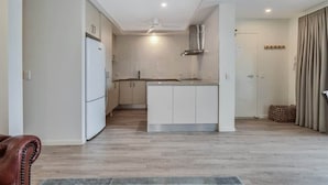 Una cocina moderna con armarios blancos, horno integrado y una isla central.