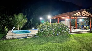 Ein überdachter Außenbereich mit Pool und Holzkonstruktion.