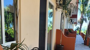 Un espacio al aire libre cubierto con una mesa, sillas, una puerta y plantas en macetas.