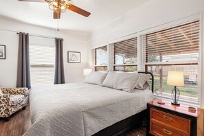 A bedroom with a bed, bedside table, lamp, and a chair. - Place on Pecan | Close to Main in Cowboy Capital (Bandera)