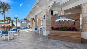 Un resort con un letrero que dice "Windsor Island Resort", mesas al aire libre y palmeras.