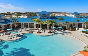 A resort with a large pool, sun loungers, and palm trees. - Disney Area 5BR Home with Heated Pool ,Resort Amenities at Windsor Island Resort (Davenport)