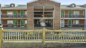 Un motel à plusieurs étages, doté d’une entrée principale, de balcons et de drapeaux américains.