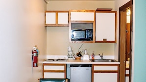 Une cuisine compacte équipée d’un four à micro-ondes, d’un évier et d’un petit coin repas avec une table et des chaises.