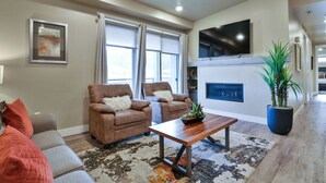 A spacious living room with a fireplace, comfortable seating, and a large TV. - SageCreek C5 - Best Pool & Red Rock View - Hot Tub (Moab)
