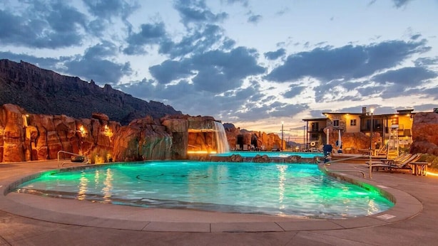 A pool with a waterfall feature, surrounded by rock formations and a mountain backdrop. - Sage Creek Resort Moab - ArchView Escape C7 (Moab)