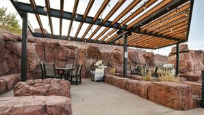 An outdoor patio with a pergola, seating, and a grill area. - Sage Creek Resort Moab - ArchView Escape C7 (Moab)