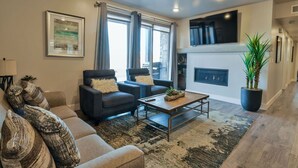 A modern living room with a sofa, two armchairs, a coffee table, and a fireplace. - Sage Creek Resort Moab - ArchView Escape C7 (Moab)