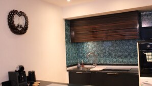 A modern kitchen with a dark countertop, a sink, and a coffee maker. - Captivating 2-bed Apartment in Edgbaston (Birmingham)