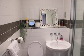 A bathroom with a toilet, sink, and shower. - Captivating 2-bed Apartment in Edgbaston (Birmingham)