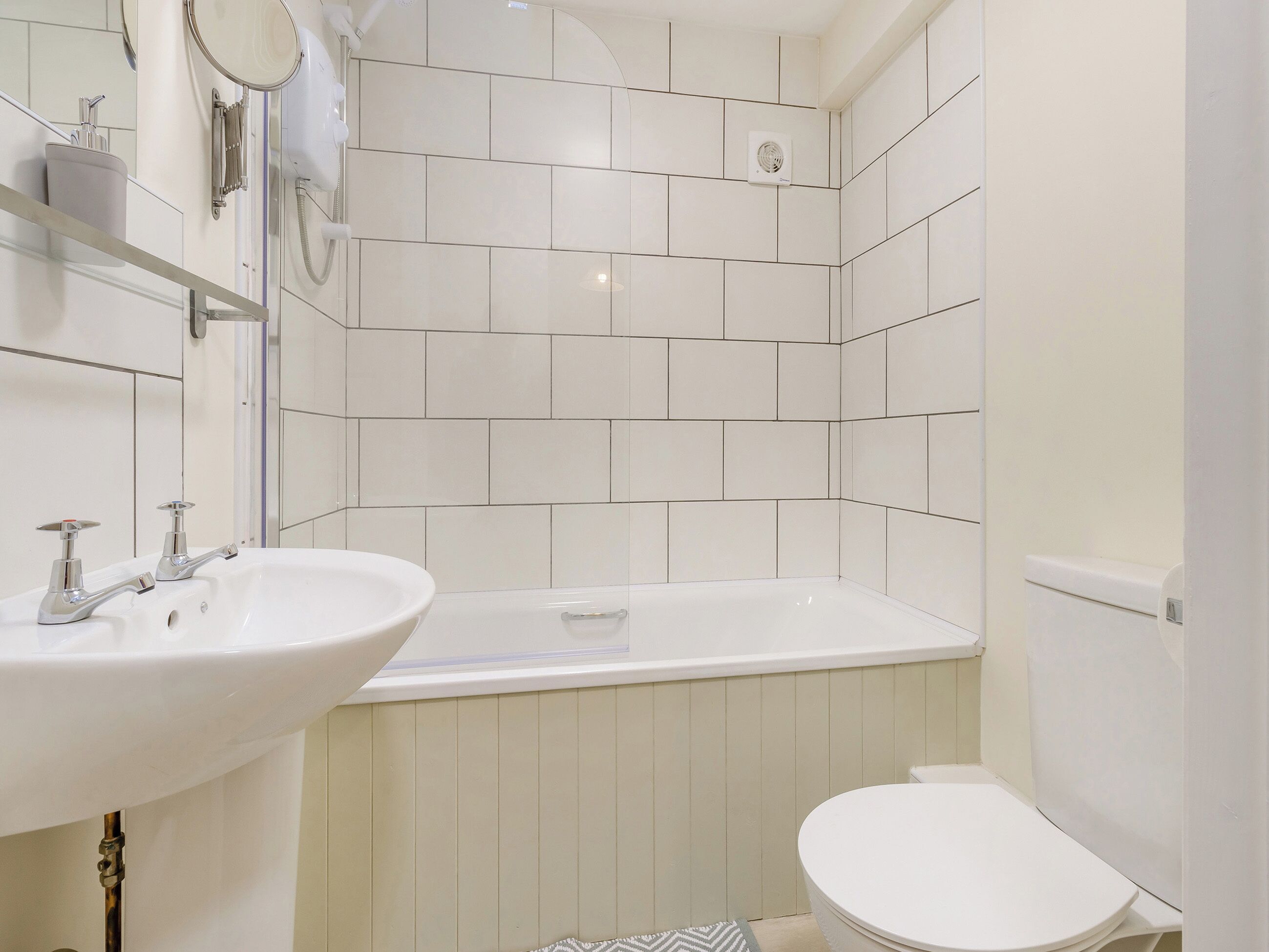 Un baño moderno con lavamanos blanco, bañera y retrete.