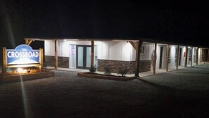 A motel named 'The Crossroad' with a signboard, covered parking area, and multiple rooms with visible doors. - The Crossroad Inn (Lineville)