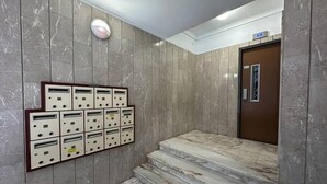 Ein mit Marmor ausgelegter Gang mit einer Wandlerputzstelle und einer Tür mit Fenster.