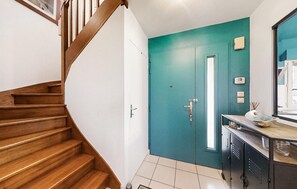 Staircase leads to a cozy space with a kitchenette and teal door.