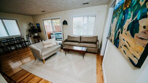 Ein Wohnzimmer mit einer Couch, einem Couchtisch und einem Gemälde an der Wand.