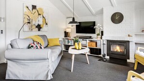 A modern living room with a grey sofa, a fireplace, a flat-screen TV, and a painting on the wall. - Awesome home in Egernsund with kitchen (Egernsund)