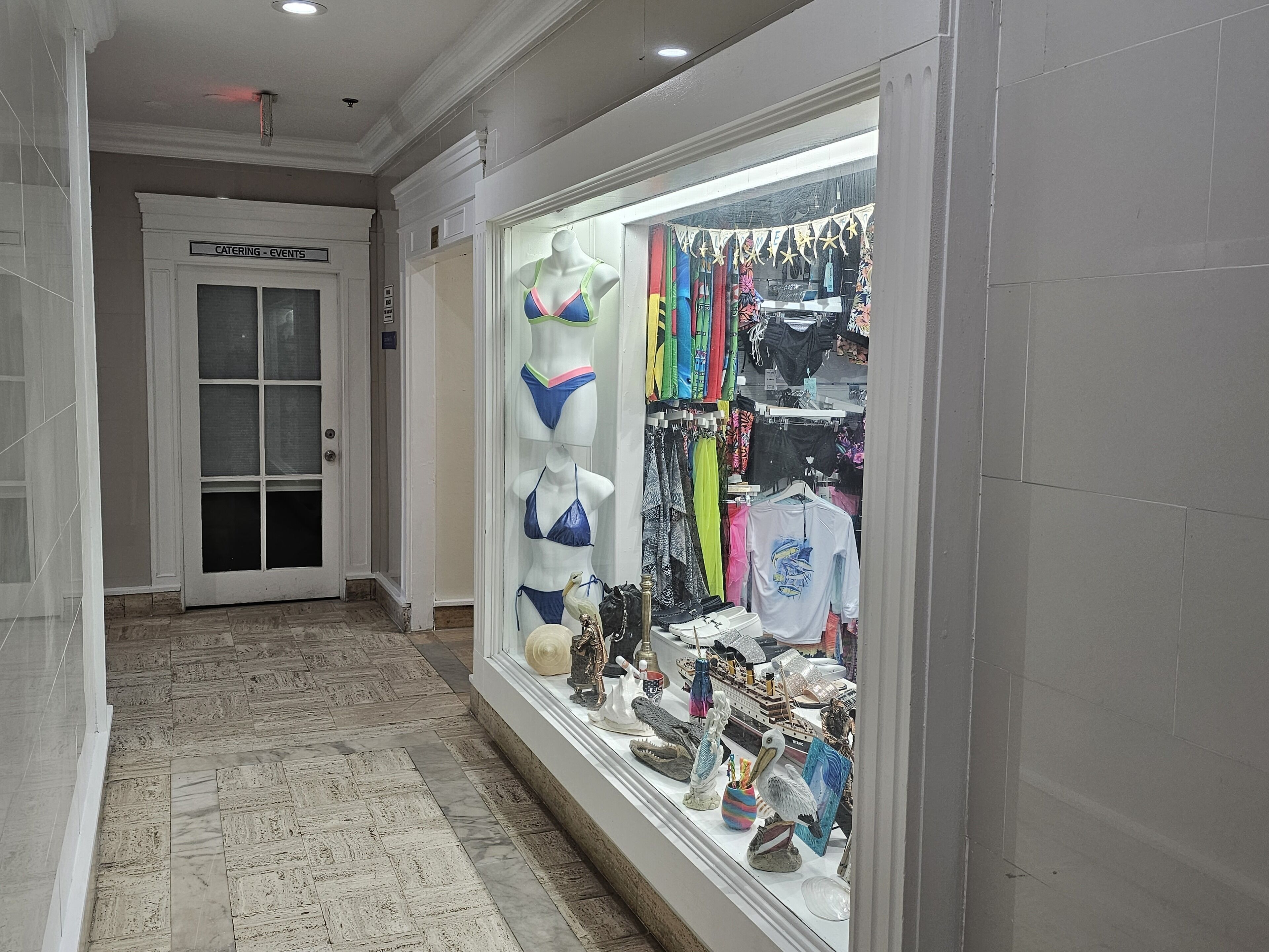 Un pasillo con un escaparate mostrando trajes de baño y accesorios.