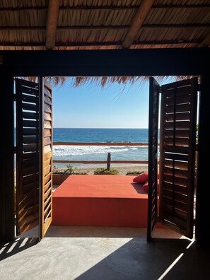 An open wooden structure with a view of the beach and ocean.