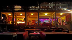 Un hôtel situé en bord de mer, doté d’une terrasse et d’un bar.