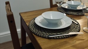 A dining table set with plates, a bowl, a glass, and a lamp. - Stylish House in Sheffield (Sheffield)