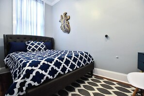 A bedroom with a bed, a wall-mounted heart decoration, and a small round table. - Claiborne Guest House w/pool by Historic Getaways (New Orleans)
