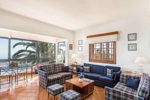 A living room with a sofa set, a coffee table, and a dining area with chairs and a table. - "Teresita High Views" with Panoramic View, Private Pool, Wi-Fi, Garden & Terrace (Santa Brígida)