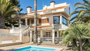 A two-story house with a swimming pool, a balcony, and a staircase leading to the upper floor.