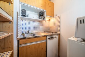 A compact kitchen with wooden cabinets, a built-in sink, a dishwasher, and a microwave. - Studio Apartment 'Samoens 1600' with Balcony (Samoëns)