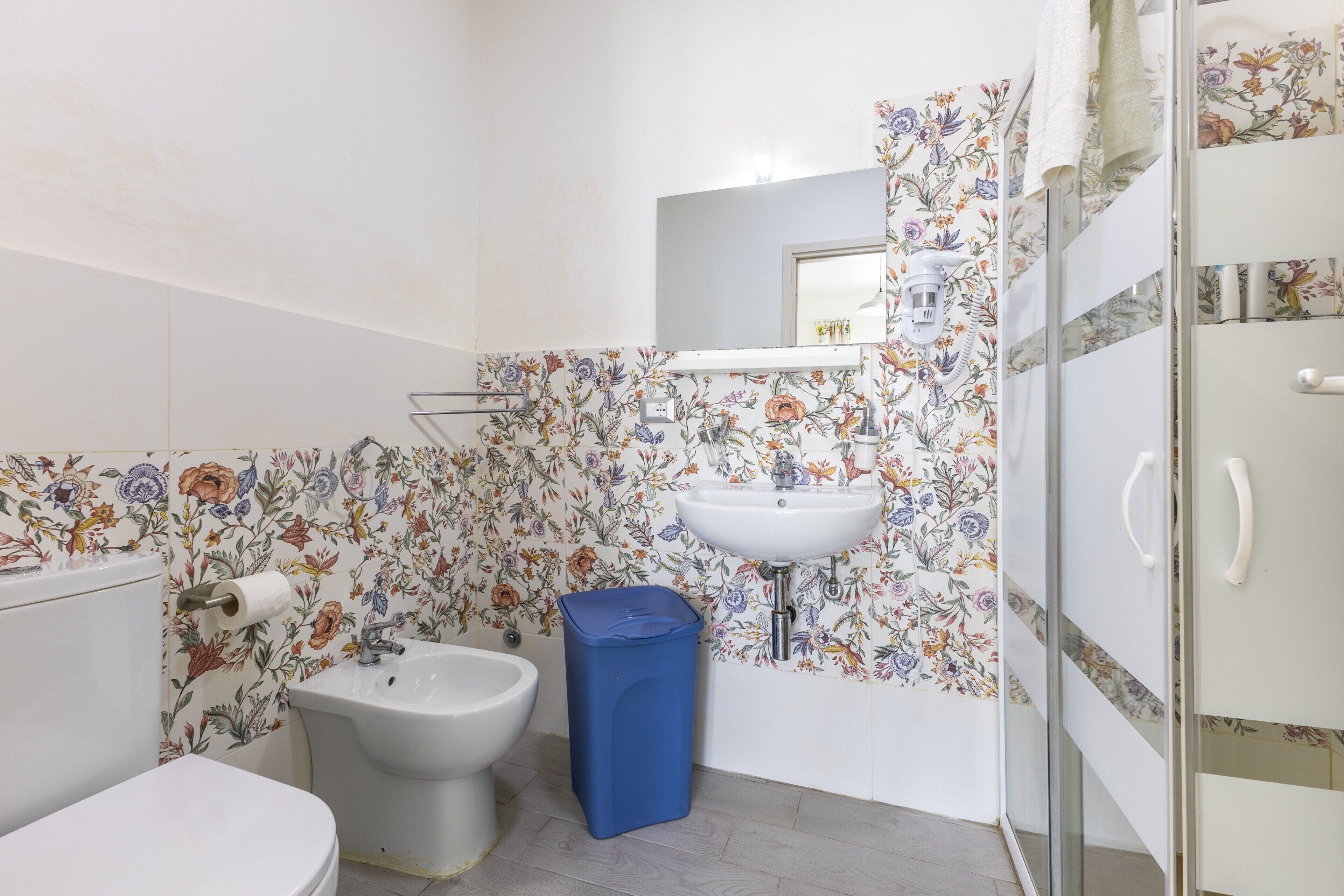 A bathroom with a toilet, bidet, sink, and shower.