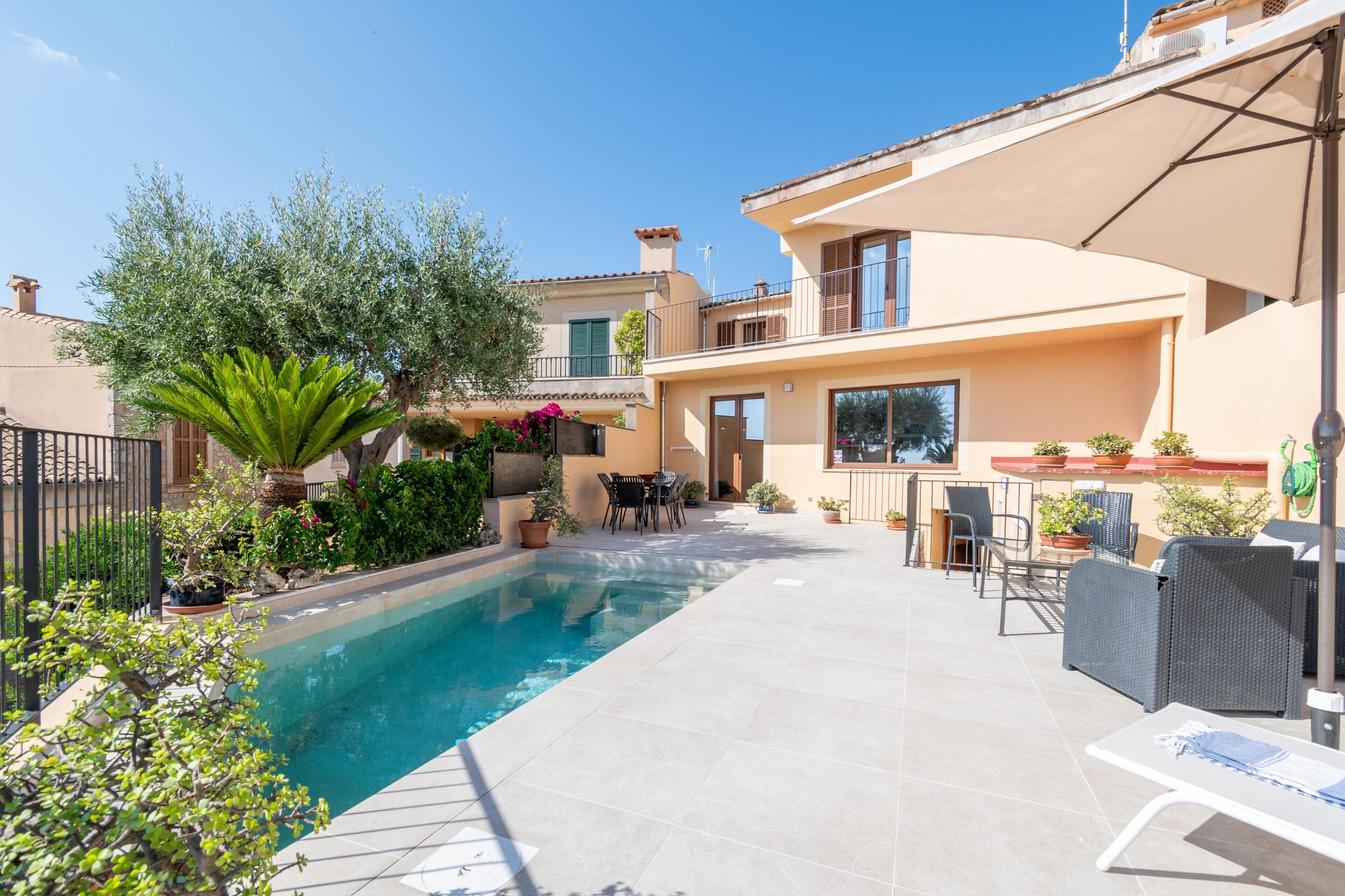 Una propietat residencial amb piscina, zona de seients a l'exterior i jardí.