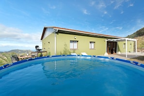 Une piscine avec une maison en arrière-plan.