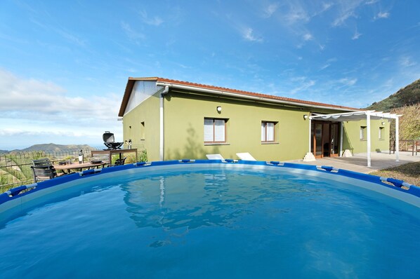 A swimming pool with a house in the background.